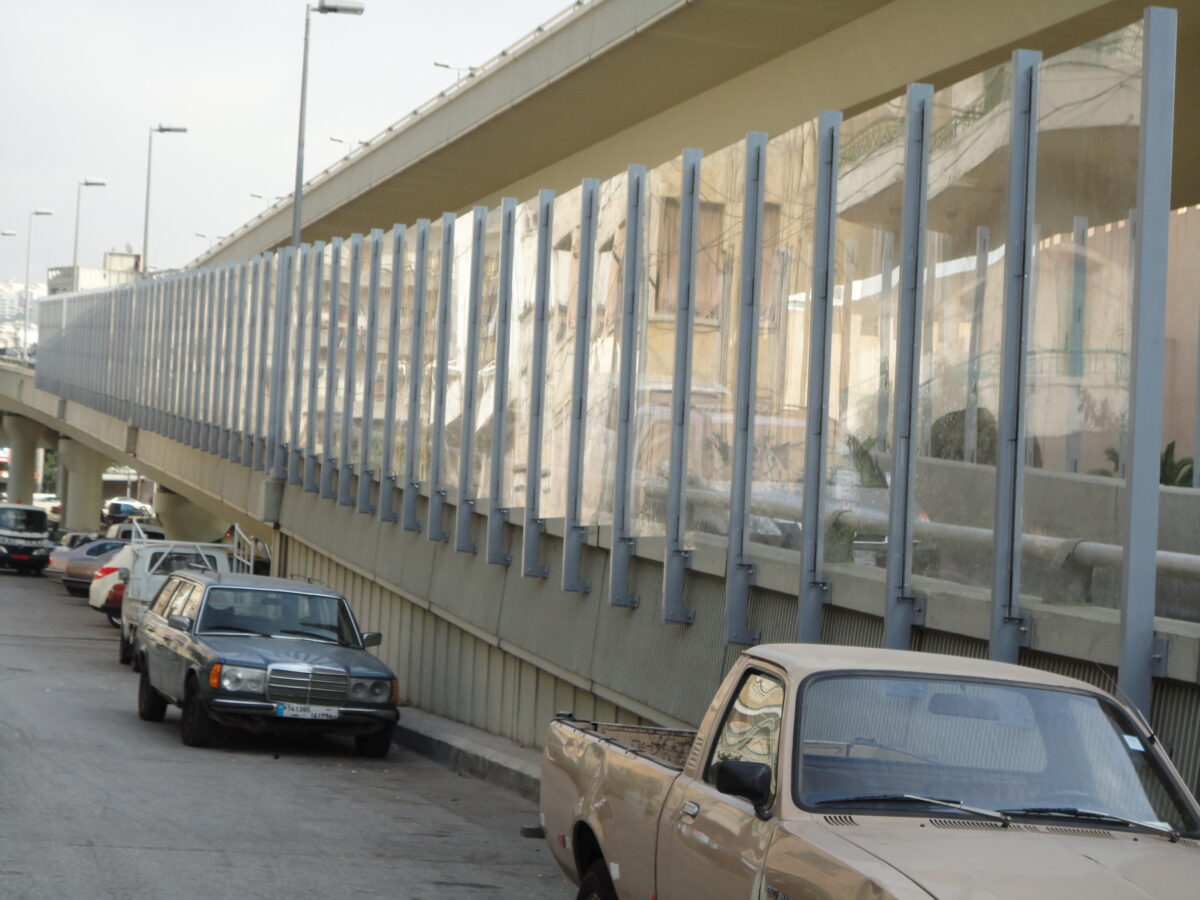 Acoustic sound barrier installed along an outdoor facility to block noise transmission.