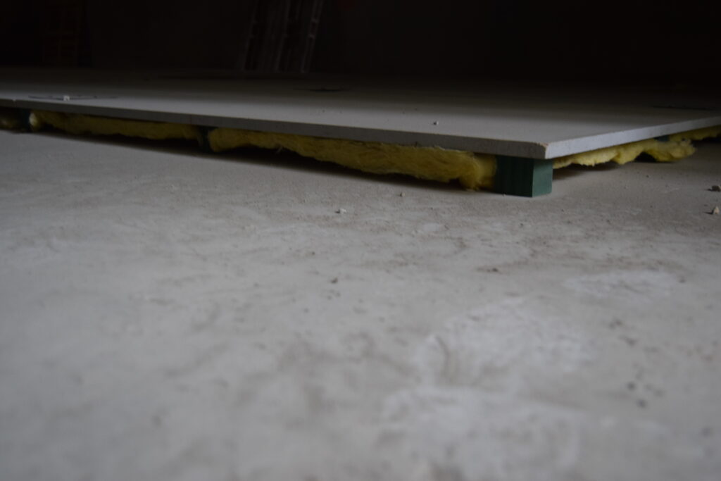 Floating floor installed on elastomeric isolators for vibration and noise control.