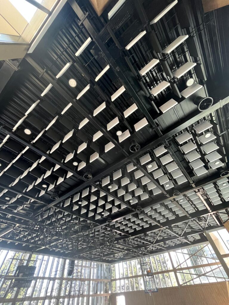 Acoustic baffles integrated with lighting and ceiling structure at International College.