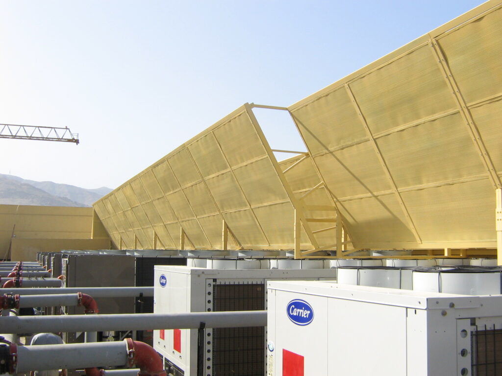Acoustic panel barrier around rooftop chillers to reduce noise emissions.