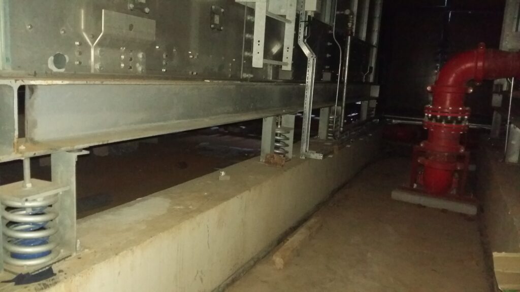 Spring anti-vibration isolator installed under MEP mechanical equipment.