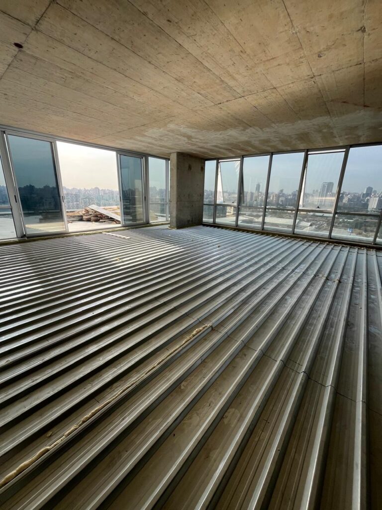 Corrugated steel sheet formwork used in a floating floor system.